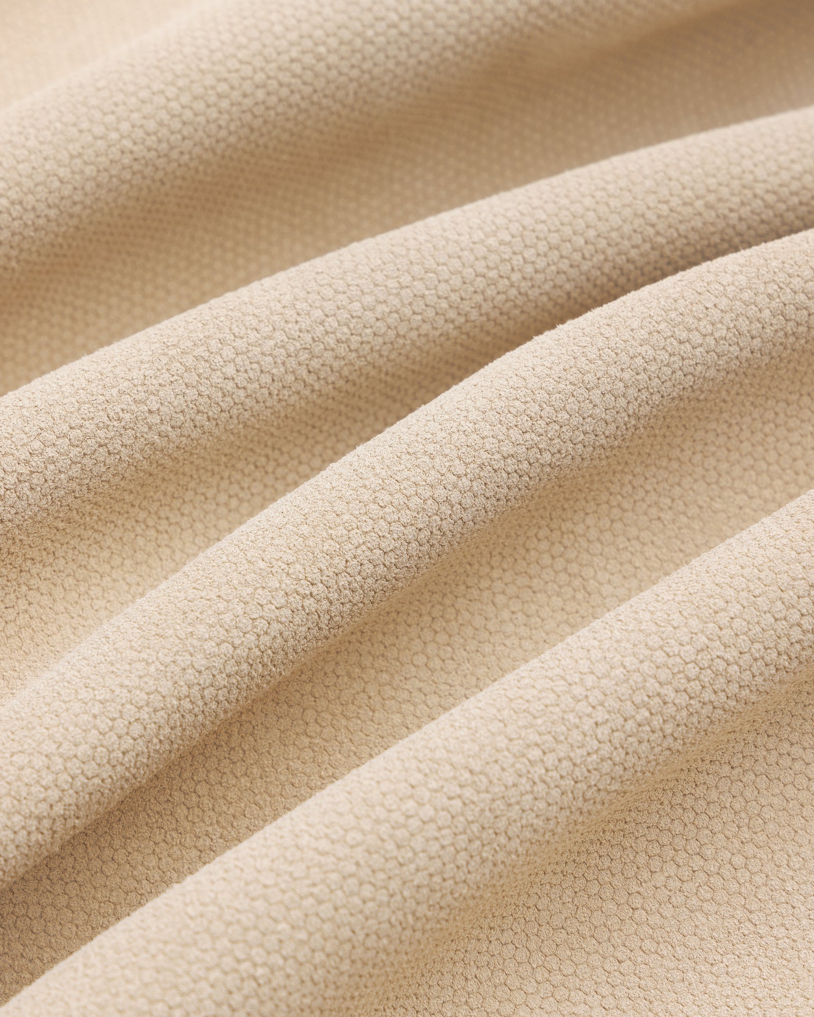 Close-up of the Leather Ranch Jacket's beige textured fabric with small hexagonal patterns and gentle folds.