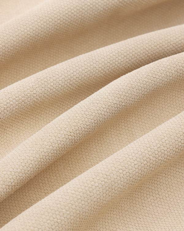 Close-up of the Leather Ranch Jacket's beige textured fabric with small hexagonal patterns and gentle folds.
