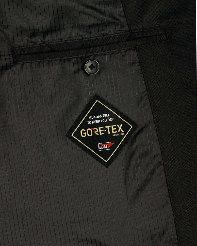 Close-up of the GORE-TEX Balmacaan Coat’s inside pocket featuring a GORE-TEX label and a single black button above it.