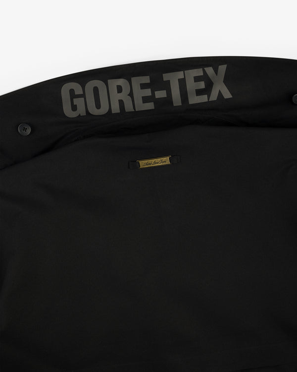 Close-up of the GORE-TEX Balmacaan Coat’s black inner collar with the GORE-TEX logo and small gold label.