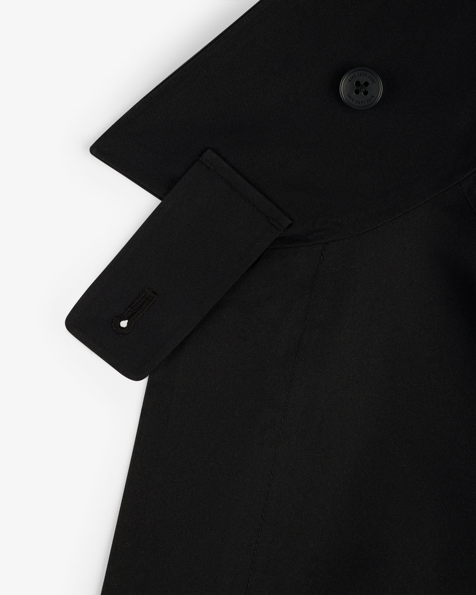 Close-up of GORE-TEX Balmacaan Coat shoulder with button, collar detail, and strap featuring a stitched buttonhole.