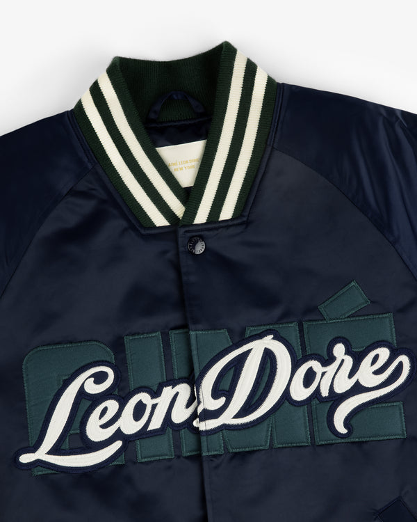 Overlay Logo Satin Varsity Jacket in navy with green/white striped collar and Leon Dore embroidery on the chest.