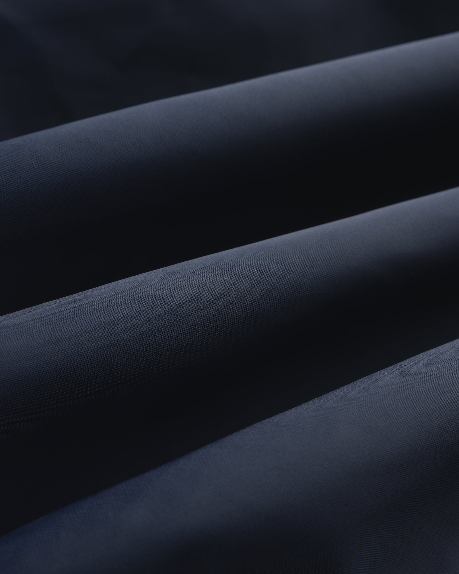 Close-up of Overlay Logo Satin Varsity Jacket in dark blue, highlighting its smooth texture and soft folds.