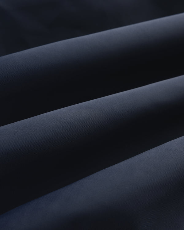 Close-up of Overlay Logo Satin Varsity Jacket in dark blue, highlighting its smooth texture and soft folds.