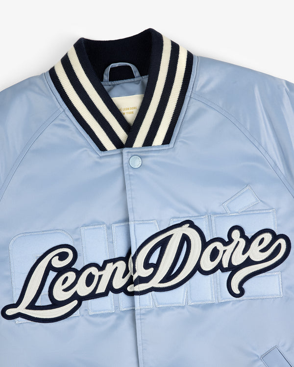 Light blue Overlay Logo Satin Varsity Jacket with striped collar and large script Leon Dore embroidery on front.