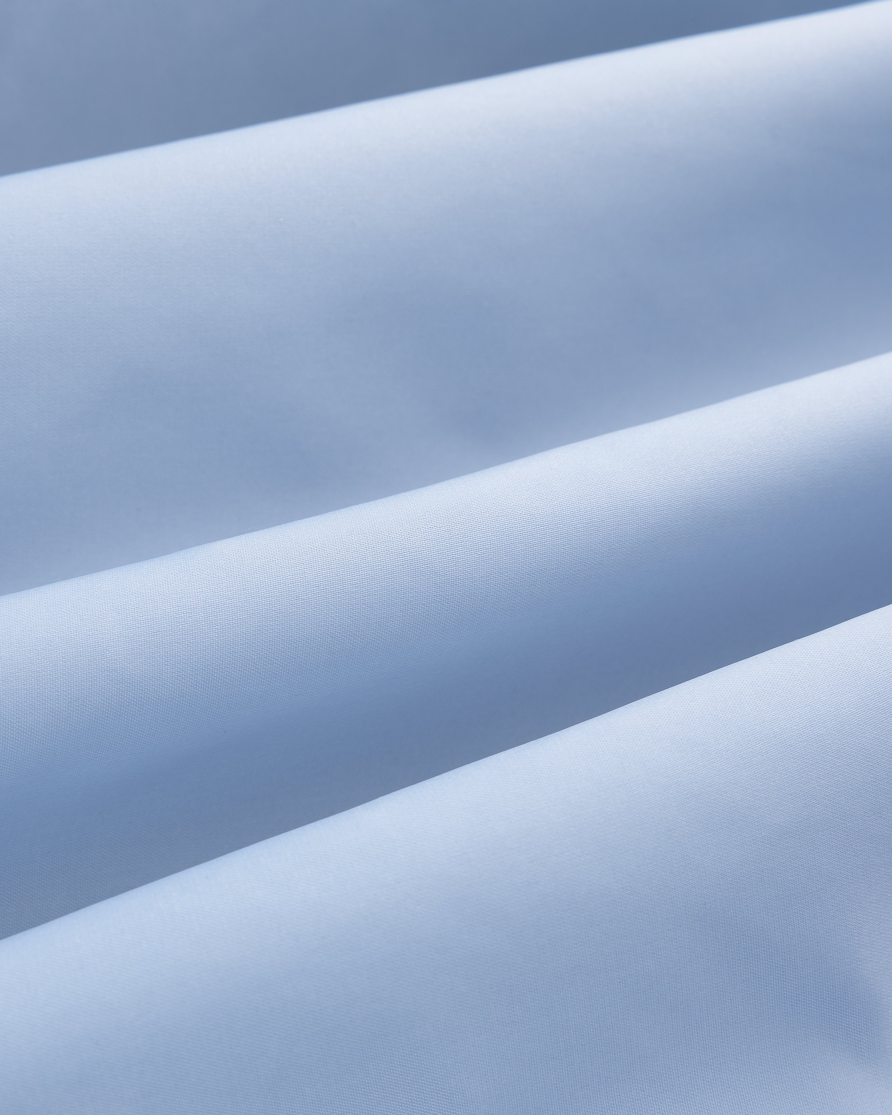 Close-up of Overlay Logo Satin Varsity Jacket in light blue, showing soft folds and smooth, gently ridged texture.