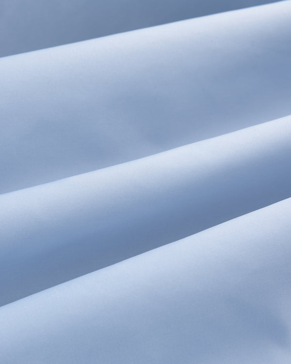 Close-up of Overlay Logo Satin Varsity Jacket in light blue, showing soft folds and smooth, gently ridged texture.