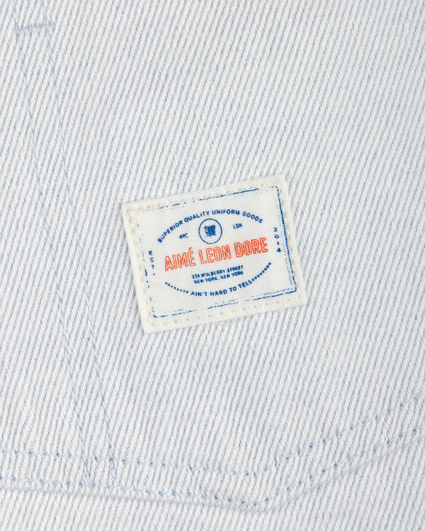 The Denim Barn Jacket features white denim and a rectangular patch label with AIMÉ LEON DORE in red and blue text.