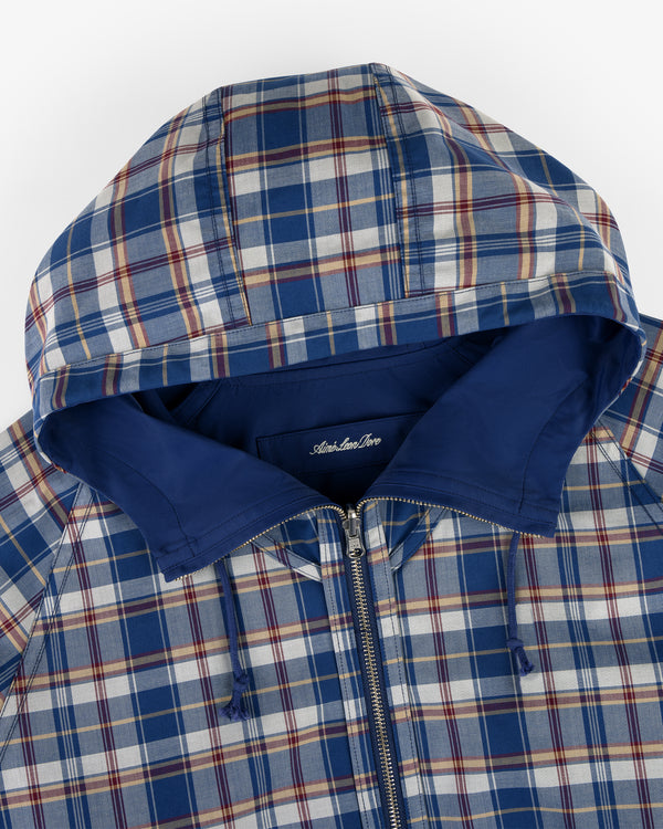 Reversible Madras Windbreaker in blue, white, and red plaid with hood, zipper, and solid blue lining, top view.