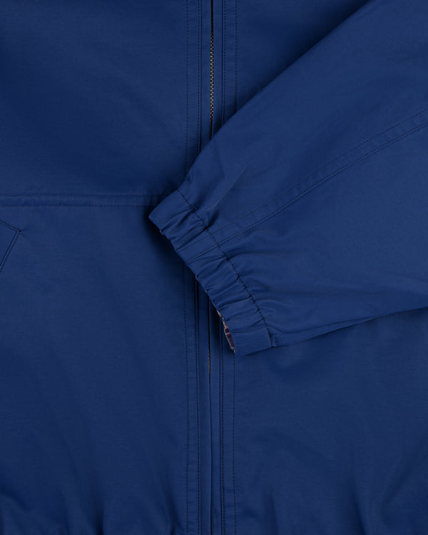 Close-up of the Reversible Madras Windbreaker, featuring a blue zipper and elastic cuff sleeve in front.