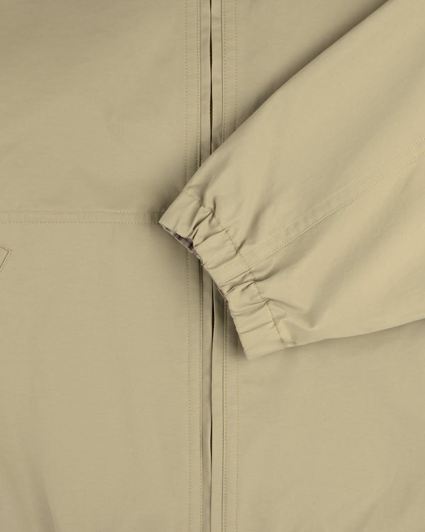 Close-up of the Reversible Madras Windbreaker in beige, highlighting the elastic cuffed sleeve and partial zipper.