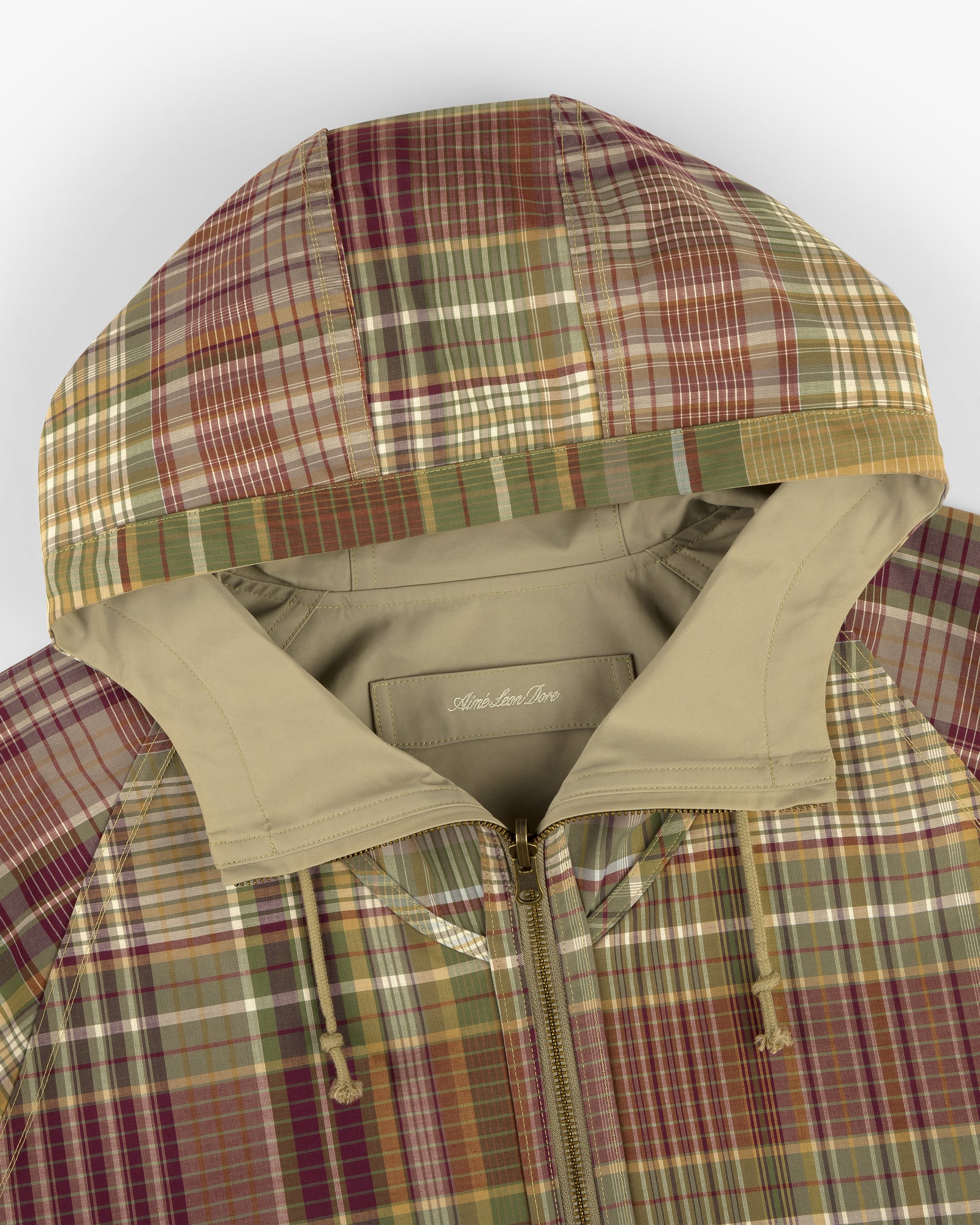Reversible Madras Windbreaker in earth-tone plaid, features a hood, front zipper, and drawstrings. Front view shown.