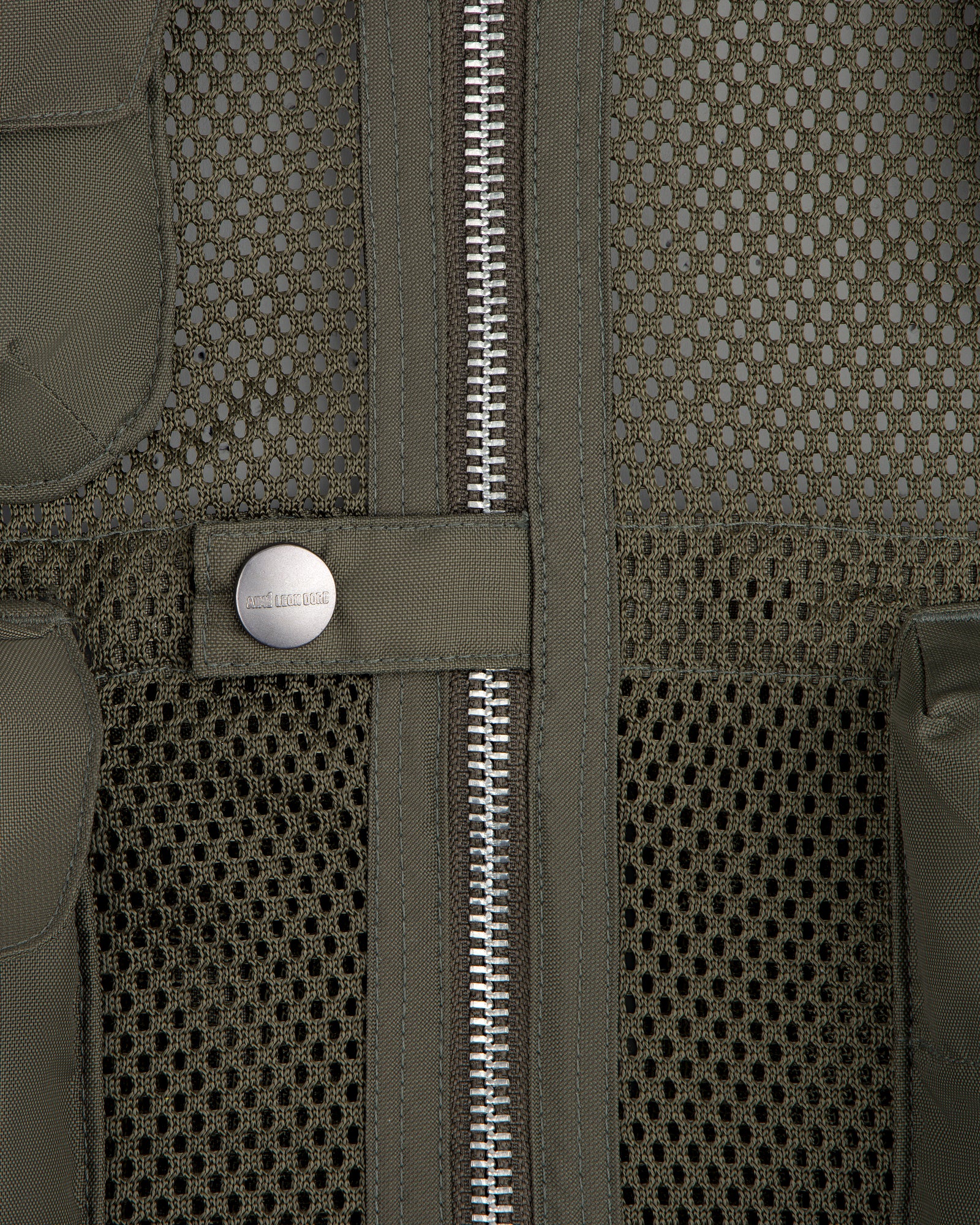 Close-up of the Nylon Utility Vest in olive green mesh, featuring a zipper and snap button pocket detail.