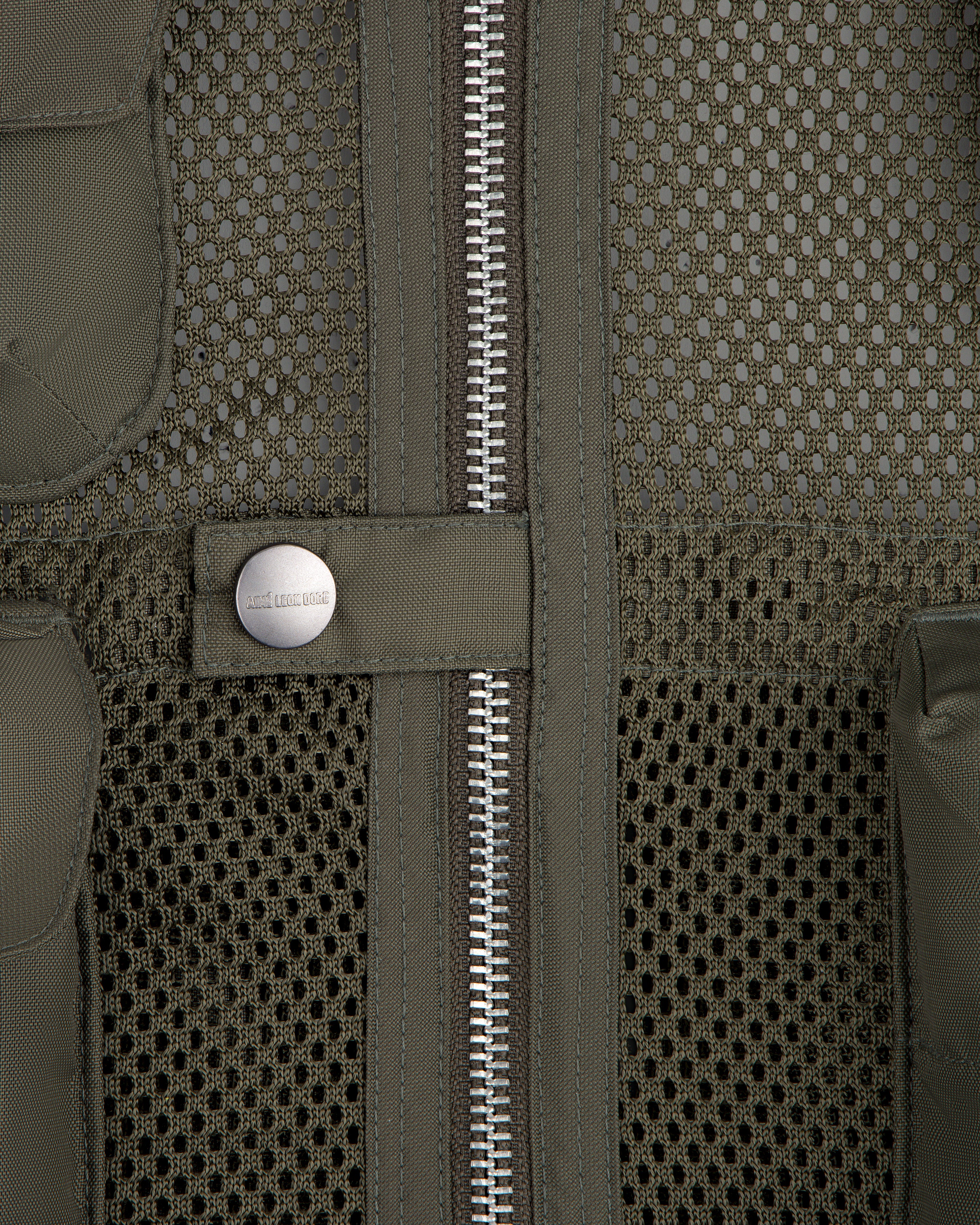 Close-up of the Nylon Utility Vest in olive green mesh, featuring a zipper and snap button pocket detail.