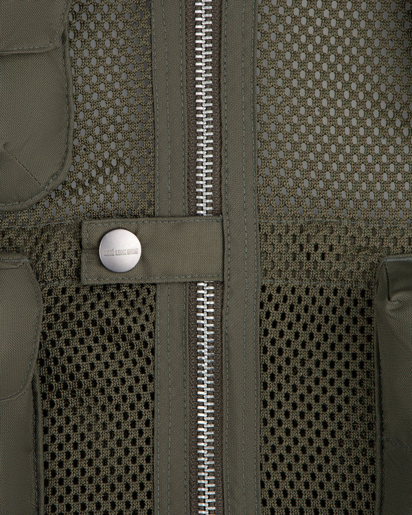 Close-up of the Nylon Utility Vest in olive green mesh, featuring a zipper and snap button pocket detail.