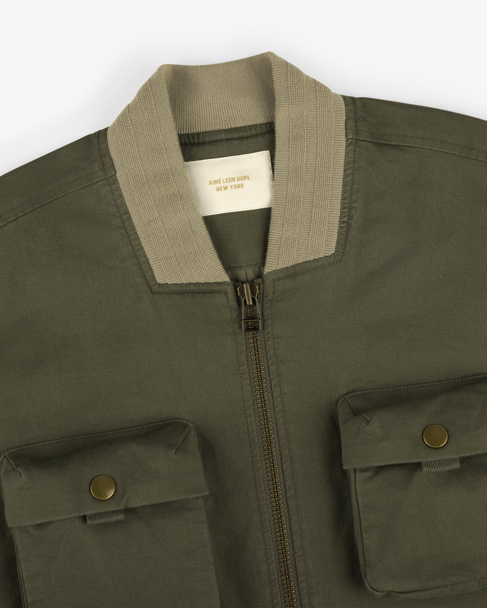 Safari Utility Bomber: olive green with beige ribbed collar, zip front, and two button-flap chest pockets.
