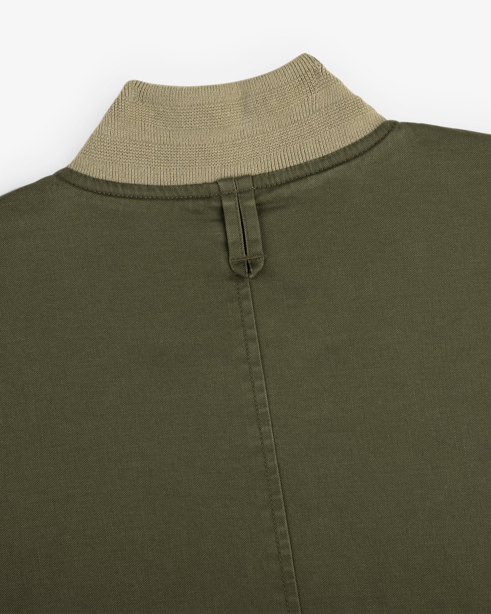Close-up of the Safari Utility Bomber in olive green with a beige ribbed collar and central back stitched seam.