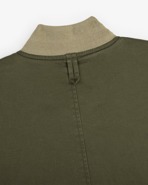 Close-up of the Safari Utility Bomber in olive green with a beige ribbed collar and central back stitched seam.