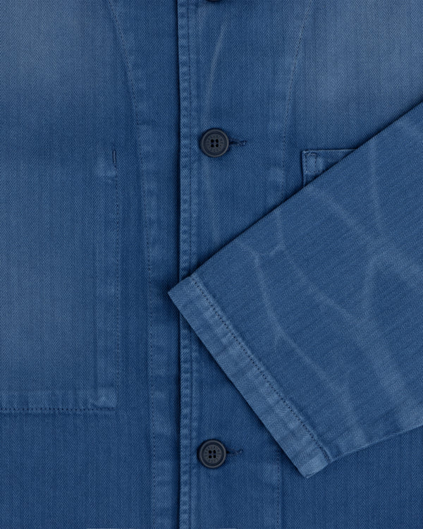 Close-up of the Sun Faded Chore Jacket in blue denim with black buttons, chest pocket, and folded sleeve detail.