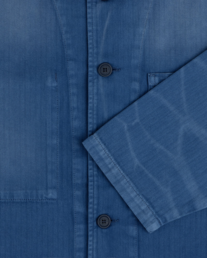 Close-up of the Sun Faded Chore Jacket in blue denim with black buttons, chest pocket, and folded sleeve detail.