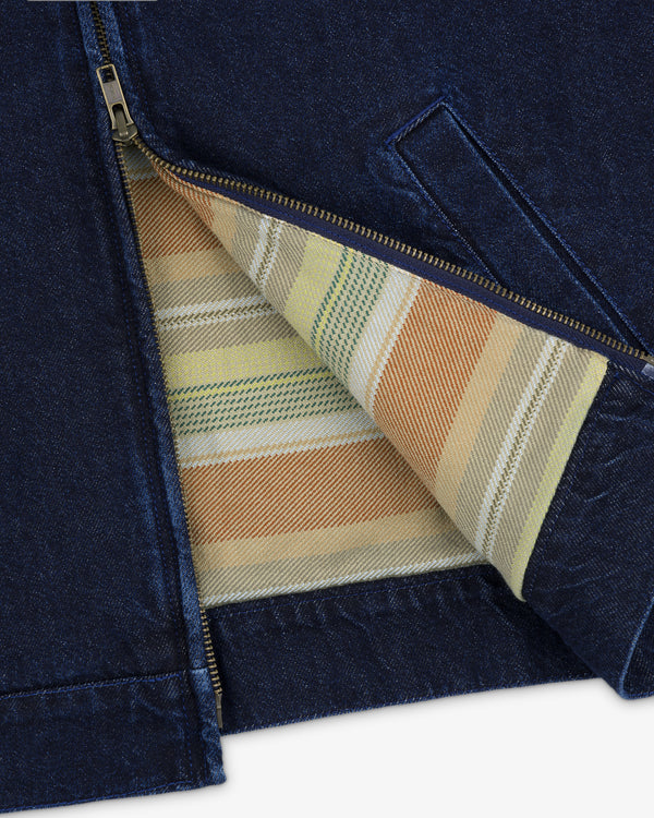 A close-up of the Denim Zip Jacket’s blue zipper partially open, showing its striped inner lining.