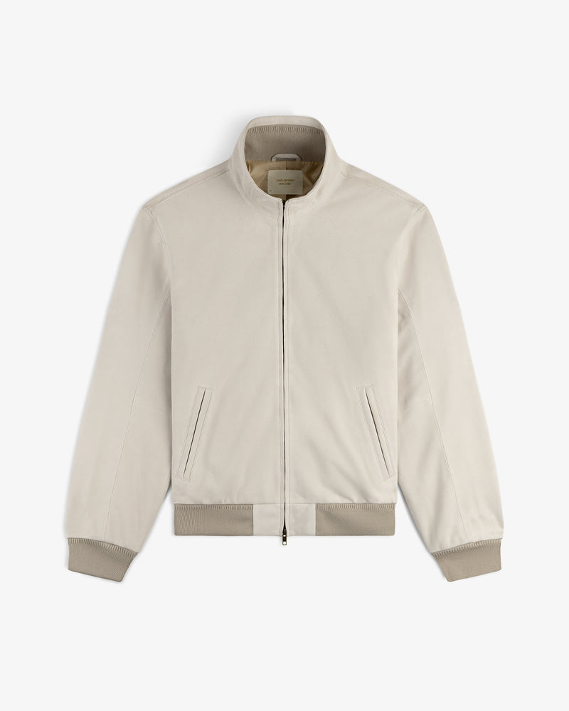 Suede Track Jacket in light beige with zip-up front, stand collar, ribbed cuffs, and side pockets, displayed flat.