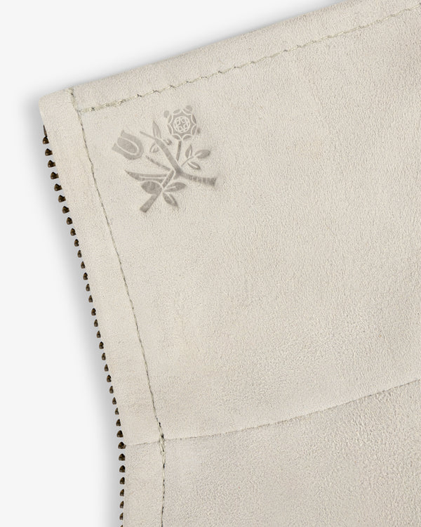 Close-up of Suede Track Jacket's light-colored suede with a subtle embossed floral design near the stitched edge.