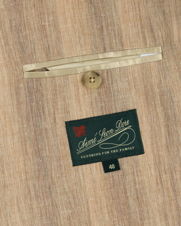 Close-up of a tan Single-Breasted Safari Suit Jacket pocket with button and Aimé Leon Dore Clothing For The Family label, size 40.