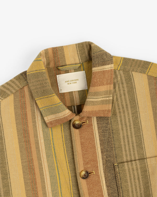 A close-up of the Blanket Striped Chore Jacket, featuring multicolored stripes, brown buttons, and a chest pocket.