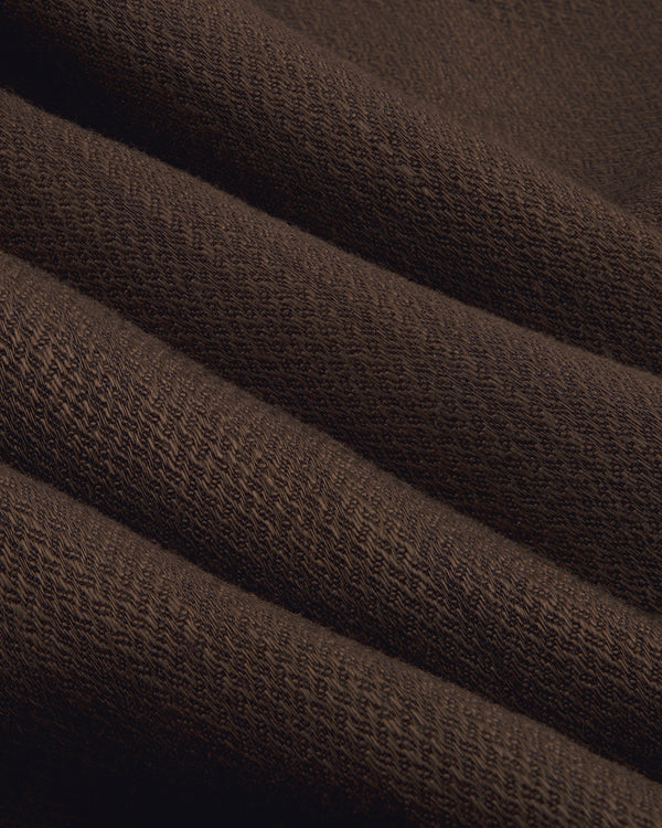 Close-up of the Single-Breasted Linen Blend Suit Jacket in dark brown with ribbed knit texture and diagonal folds.