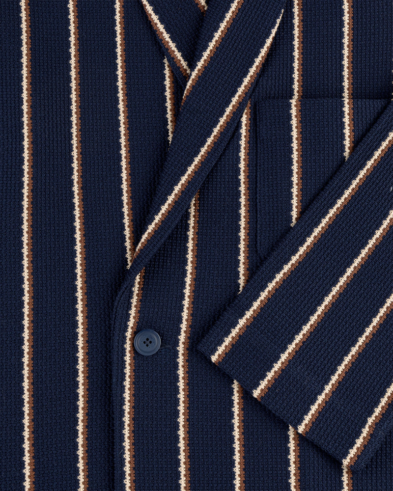 Close-up of the Striped Jacquard Shawl Collar Jacket in navy with white and brown stripes, front pocket, and button.