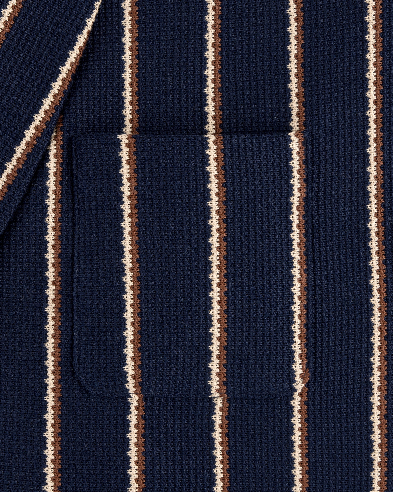 Close-up of the Striped Jacquard Shawl Collar Jacket in navy with vertical white and brown stripes and a patch pocket.