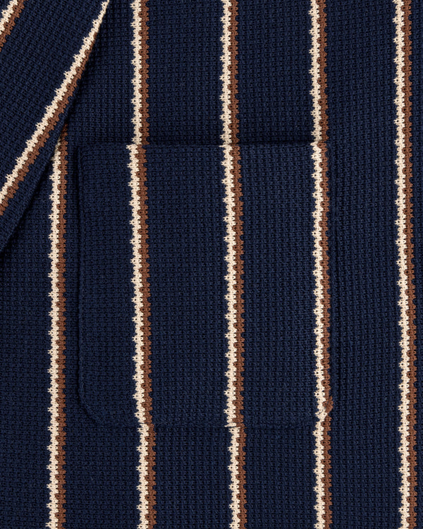 Close-up of the Striped Jacquard Shawl Collar Jacket in navy with vertical white and brown stripes and a patch pocket.
