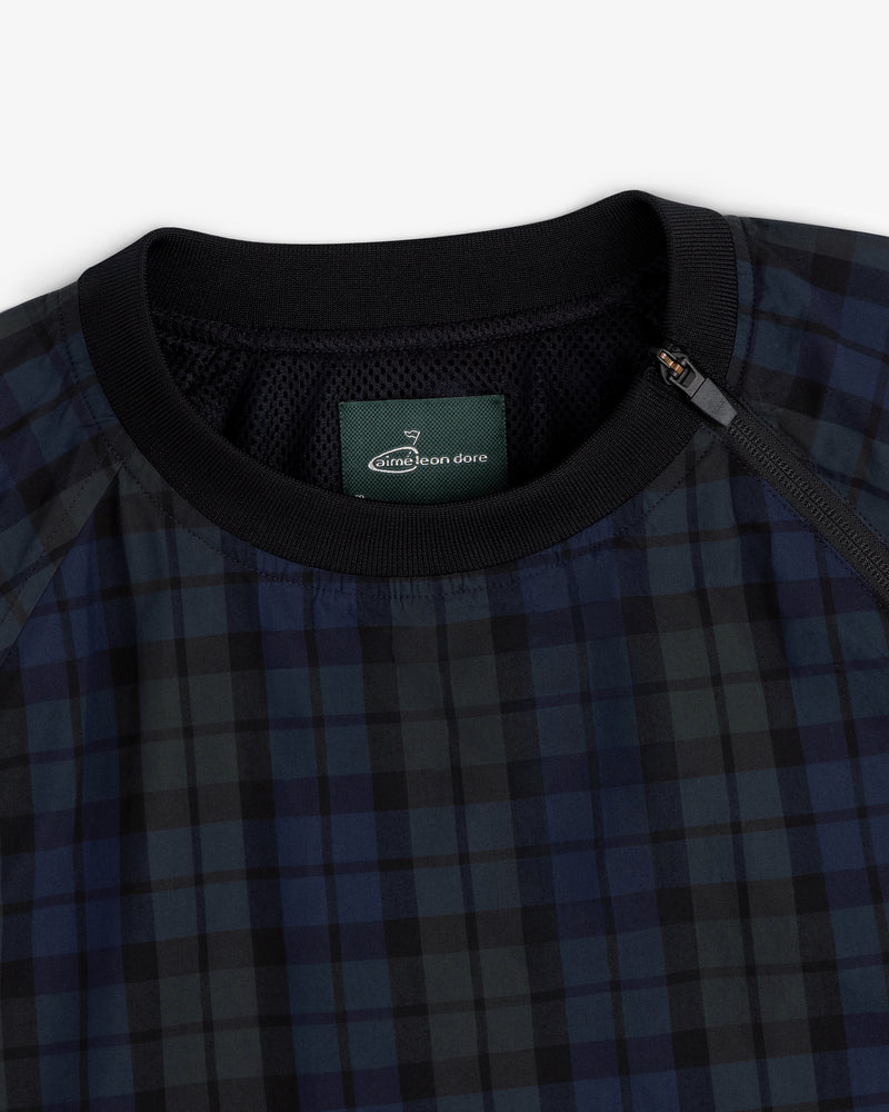 Close-up of the ALD Golf Blackwatch Pullover, featuring navy and black plaid with a black collar and Aimé Leon Dore label.