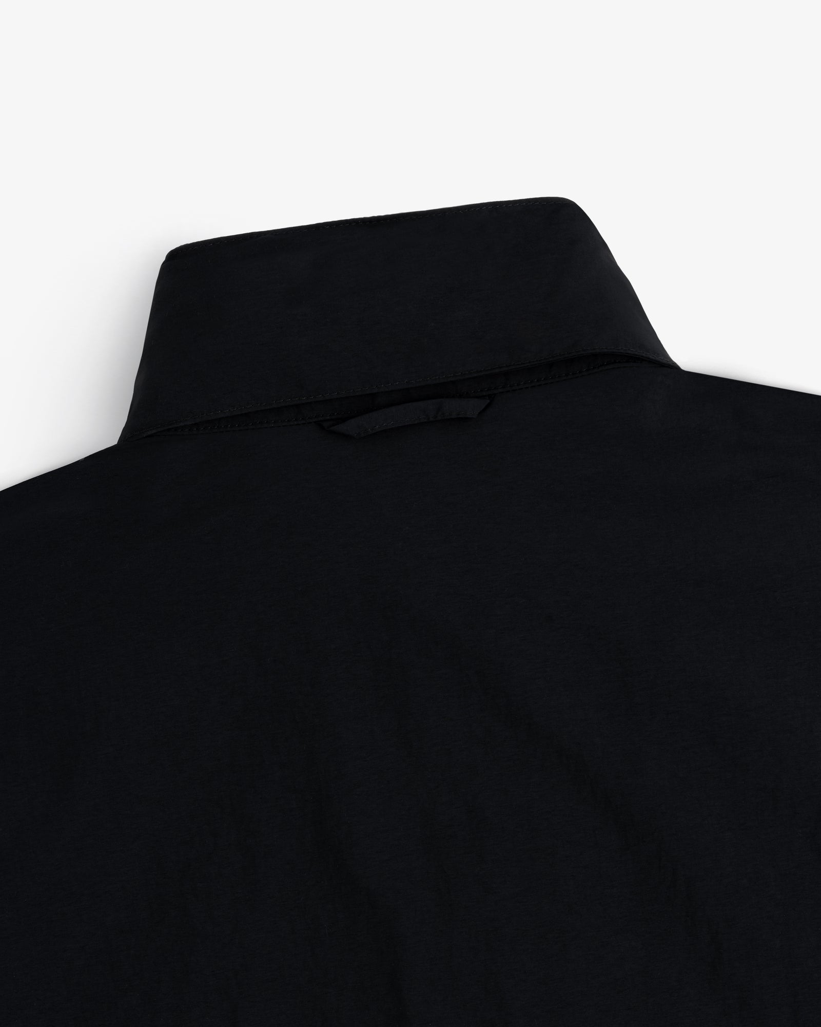 Close-up of the back of a black Nylon Track Jacket against a white background.
