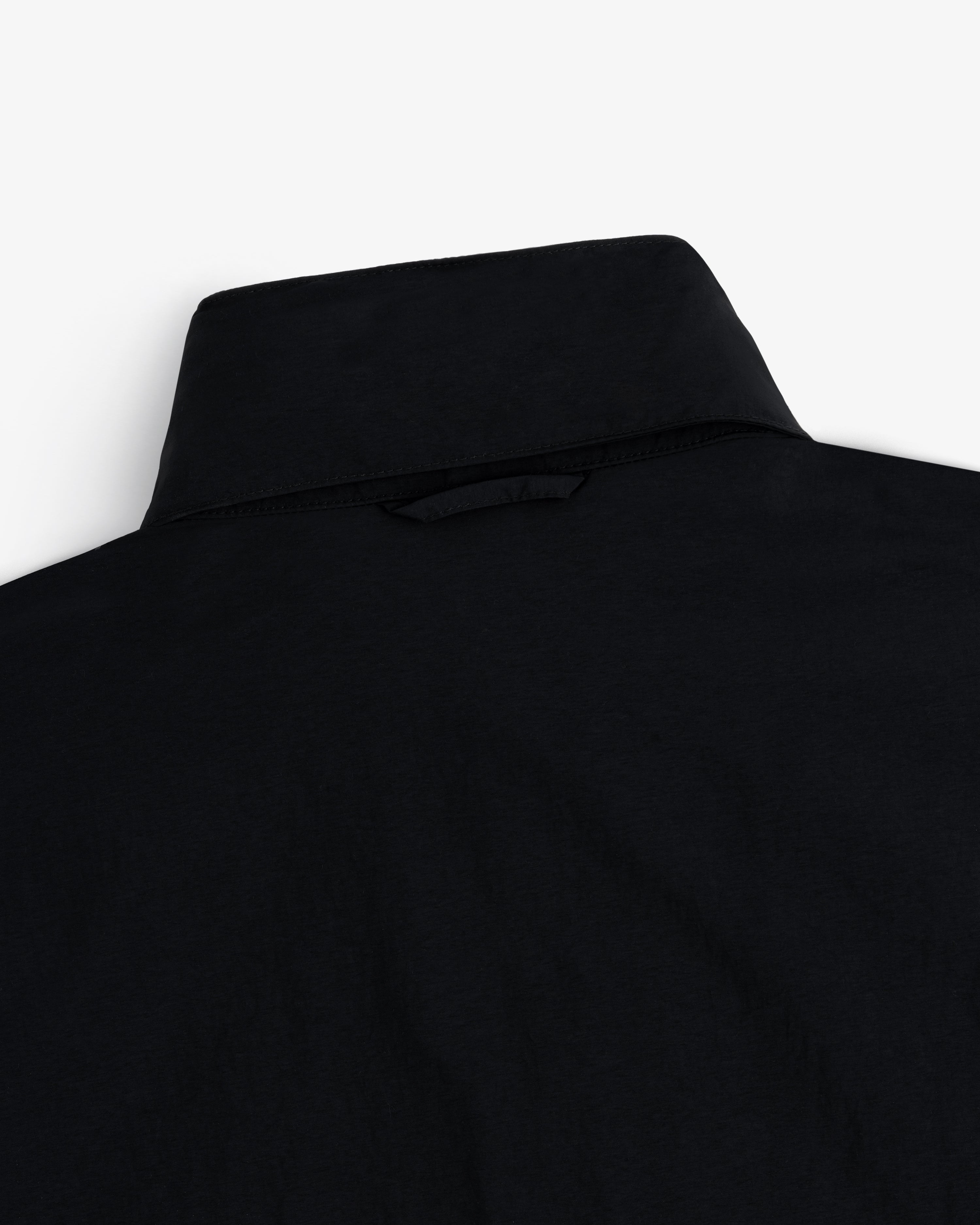 Close-up of the back of a black Nylon Track Jacket against a white background.