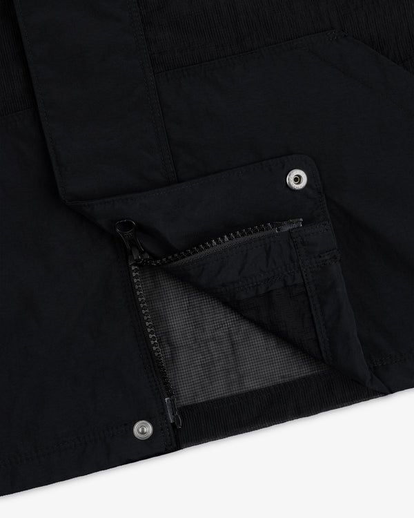 Close-up of the Nylon Track Jacket featuring a zippered pocket and metal snap buttons on black fabric.