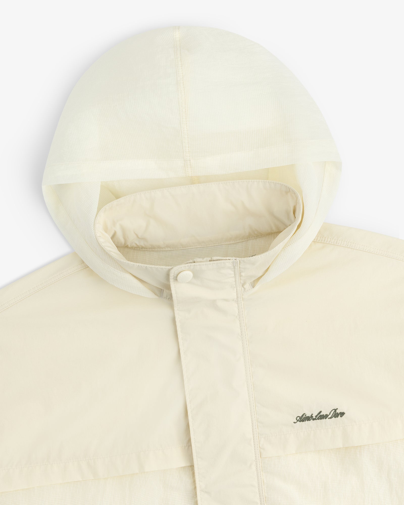 Cream nylon track jacket with hood, snap-button flap, and subtle embroidered chest logo.