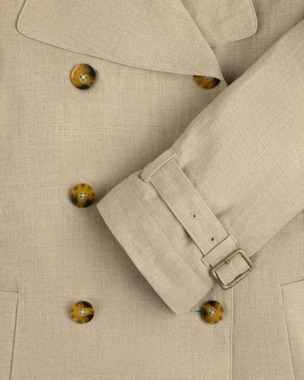 Close-up of Linen Trench Coat with brown buttons and belted cuff, highlighting the detailed fabric texture.