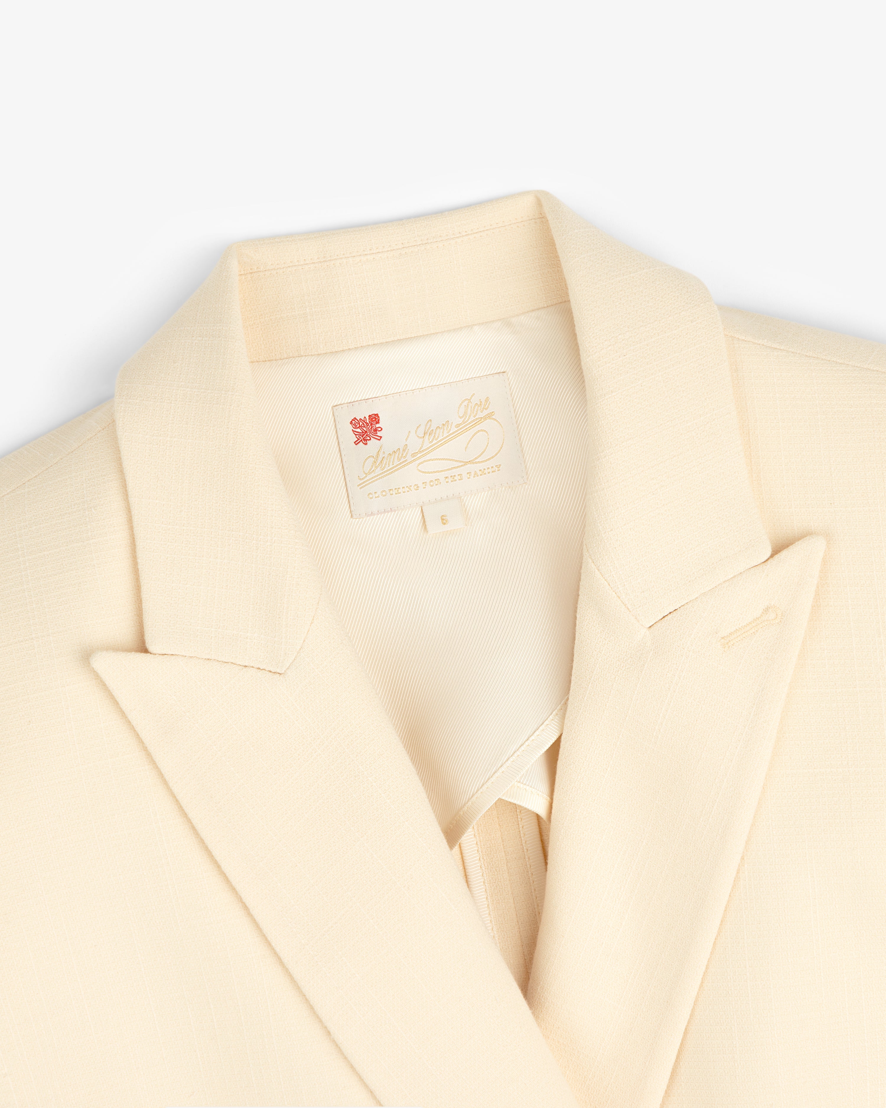 Close-up of the Double-Breasted Unconstructed Blazer in cream with notched lapel and sewn-in collar label.