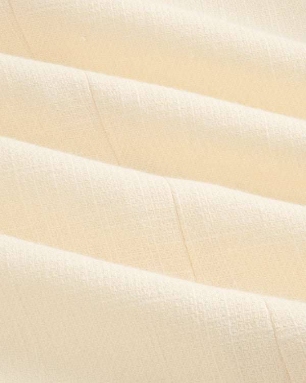 Close-up of cream-colored textured fabric with subtle grid pattern on a Double-Breasted Unconstructed Blazer.