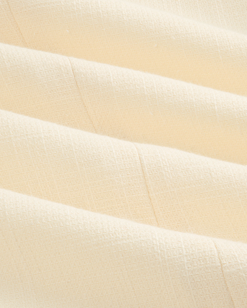 Close-up of cream-colored textured fabric with subtle grid pattern on a Double-Breasted Unconstructed Blazer.