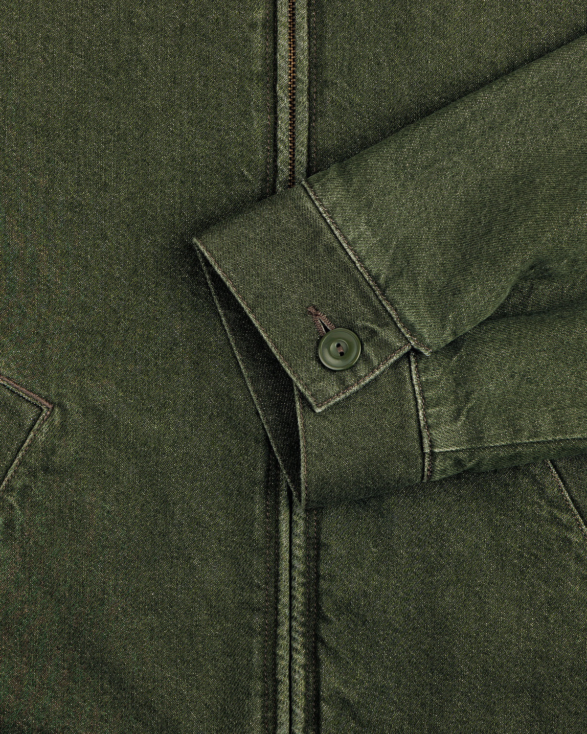 Close-up of a green Denim Zip Jacket sleeve with a buttoned cuff and visible stitching against the jacket’s body.