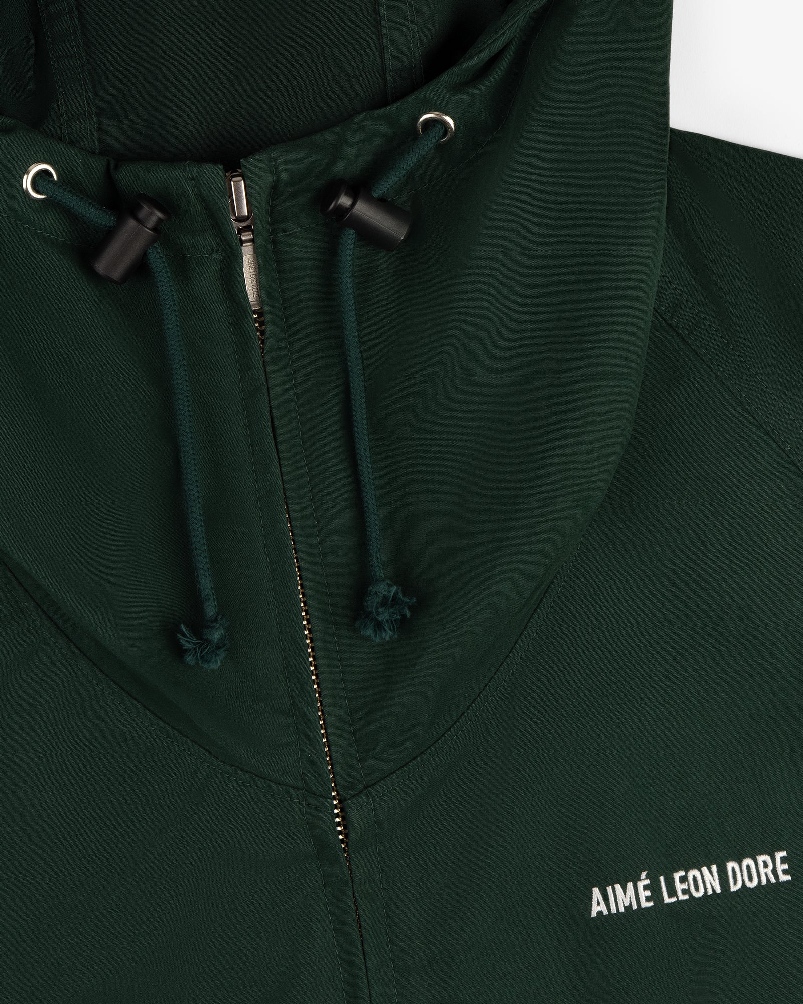 Dark green Micro Logo Lightweight Jacket with zipper, hood drawstrings, and white AIMÉ LEON DORE embroidery.