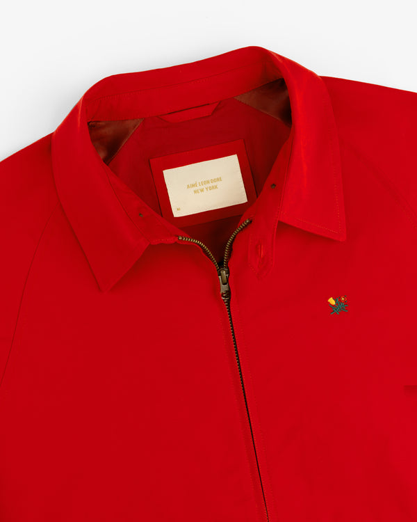 Crest Casual Jacket: bright red with zipper, pointed collar, and small colorful chest logo.