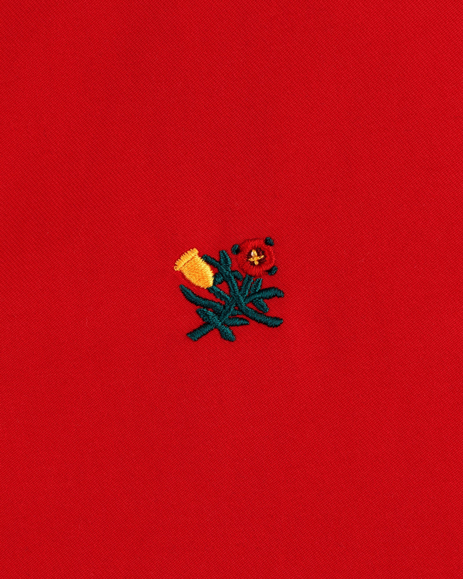 Small yellow and red embroidered flowers with green stems adorn the Crest Casual Jacket’s bright red fabric.