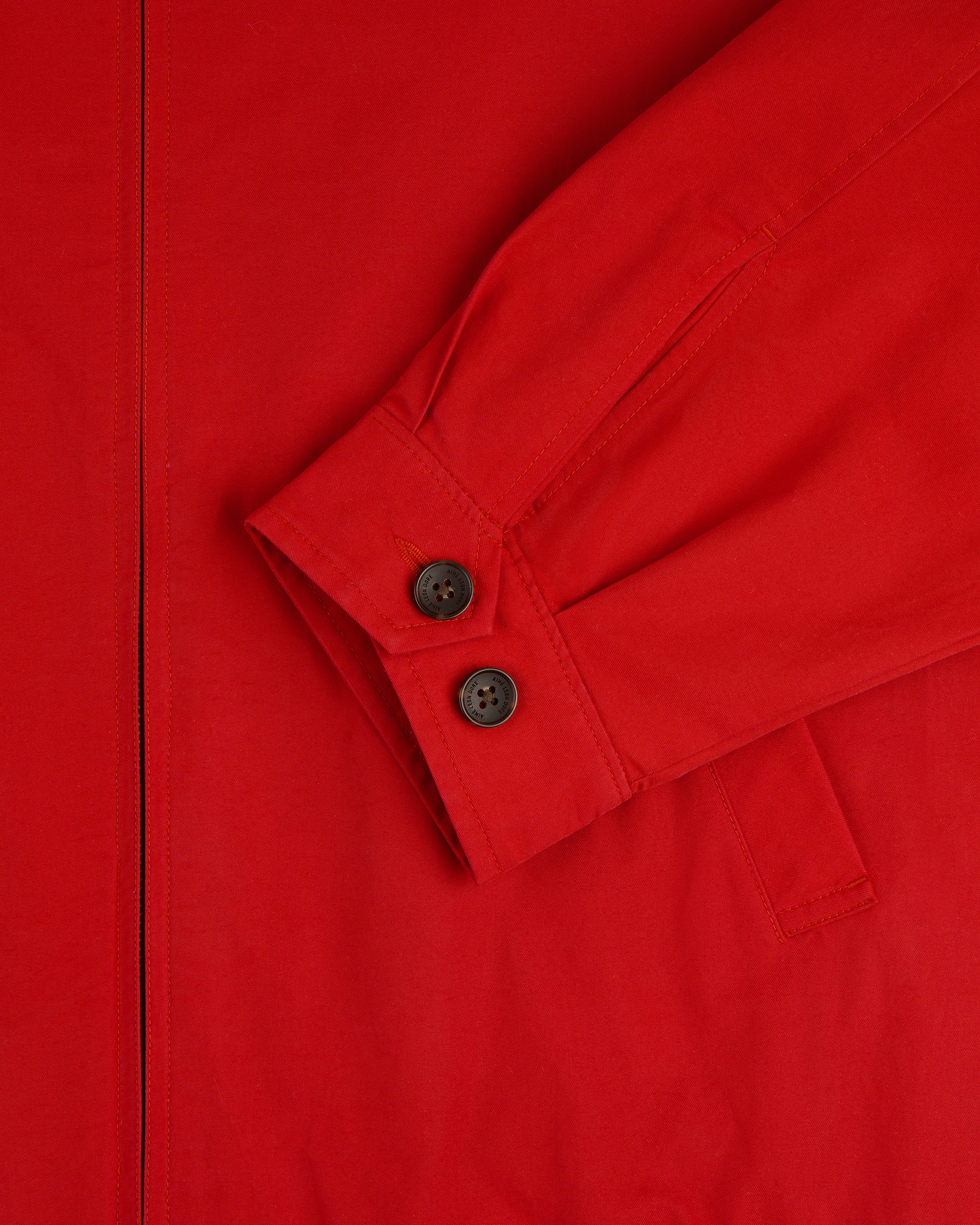 Close-up of the Crest Casual Jacket in red, featuring a long sleeve with two black cuff buttons and a visible seam.