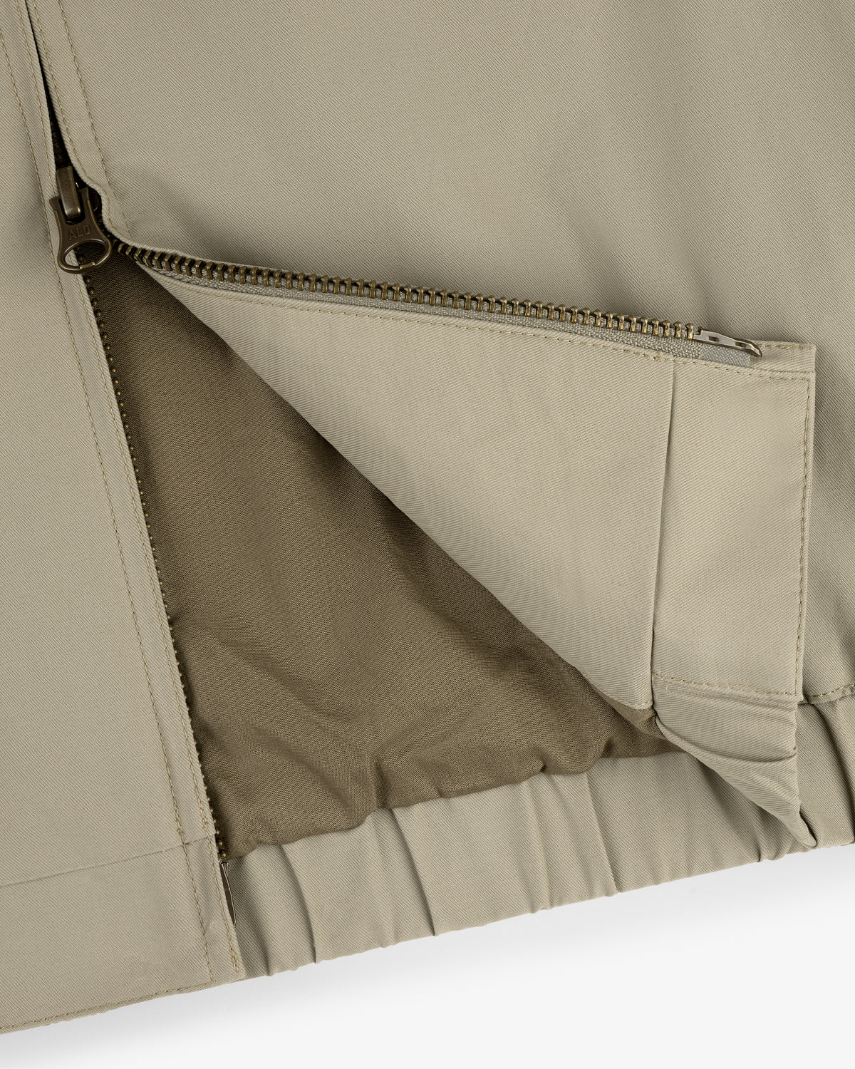 Close-up of the Crest Casual Jacket in beige with a partially unzipped pocket showing inner lining details.