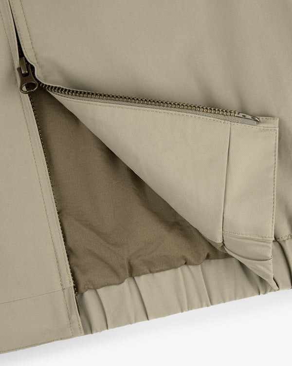 Close-up of the Crest Casual Jacket in beige with a partially unzipped pocket showing inner lining details.