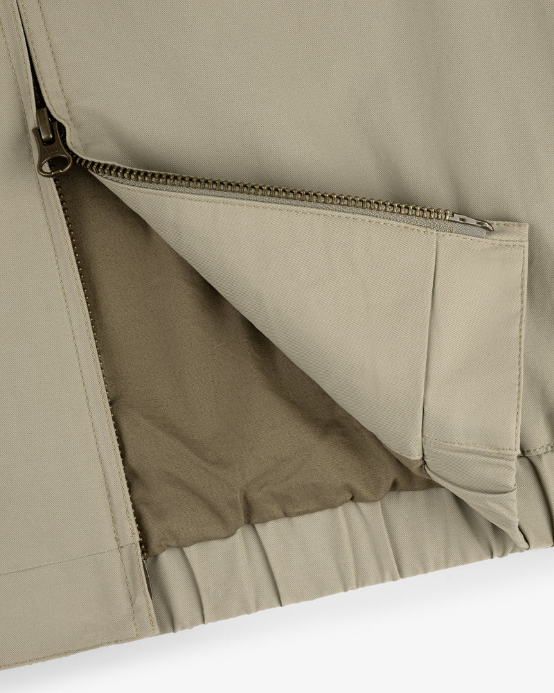 Close-up of the Crest Casual Jacket in beige with a partially unzipped pocket showing inner lining details.